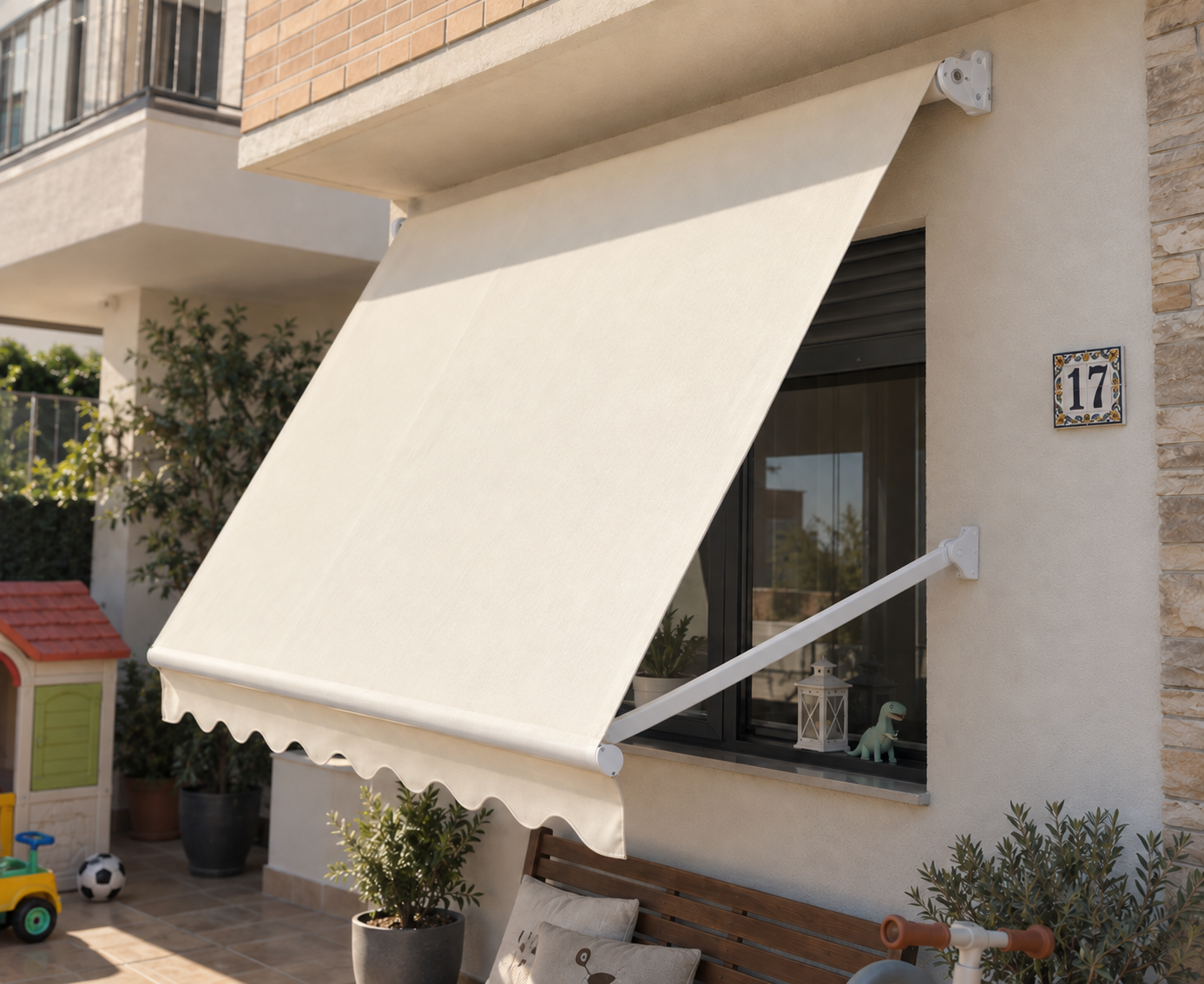 Toldo punto recto crema sobre ventana de vivienda con banco de madera