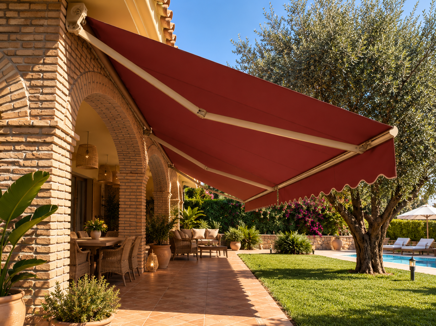 Toldo extensible rojo en una casa mediterránea con jardín y piscina