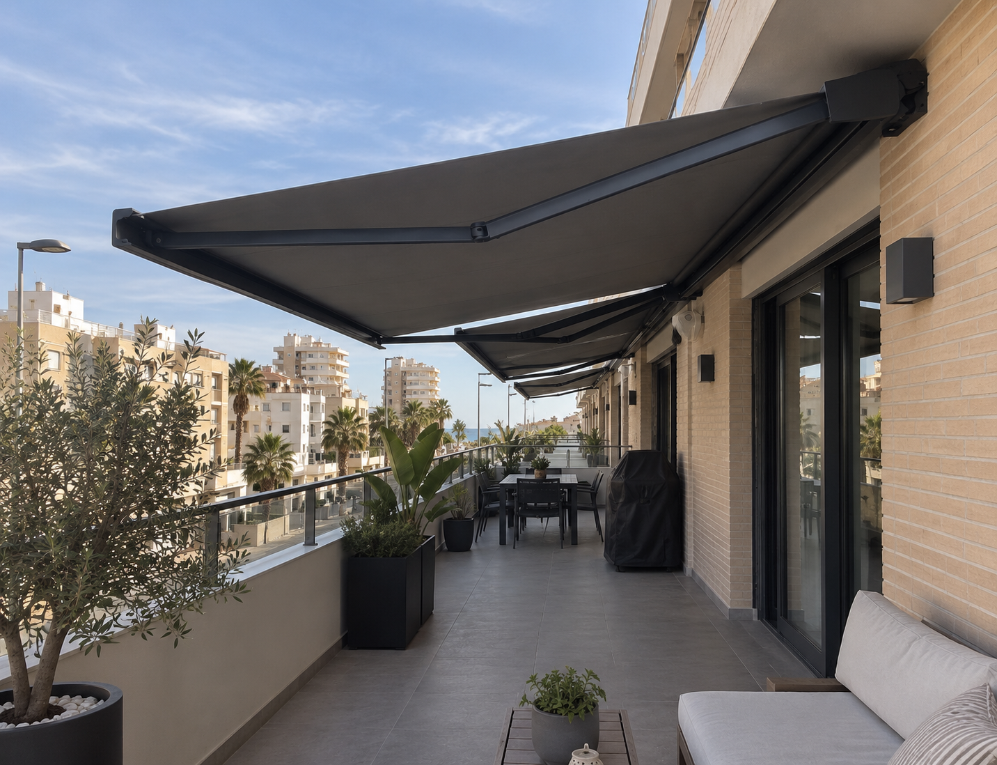 Toldos motorizados antracita en una terraza con vistas al mar