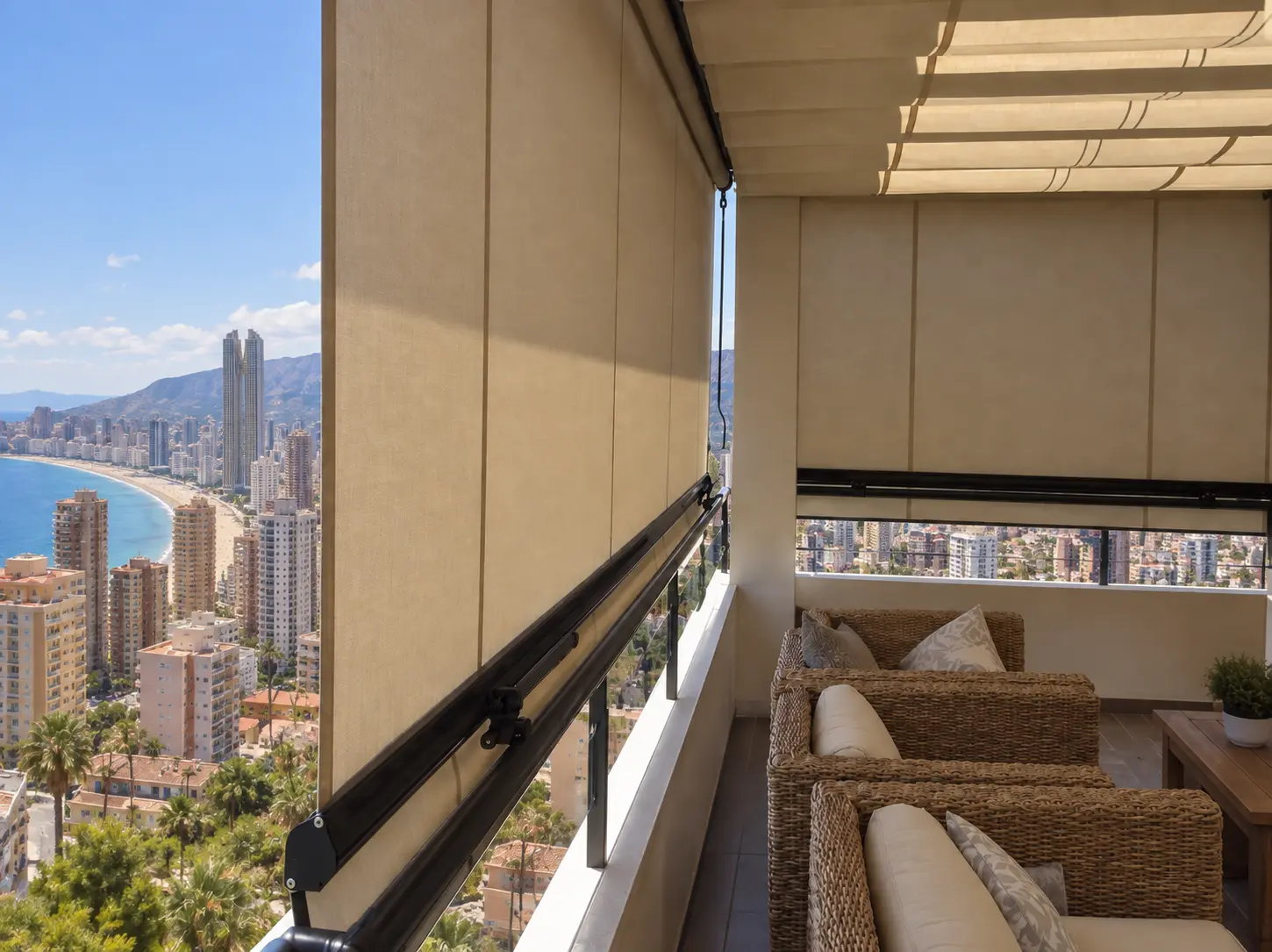 Toldos store beige en balcón con vistas a la ciudad y al mar